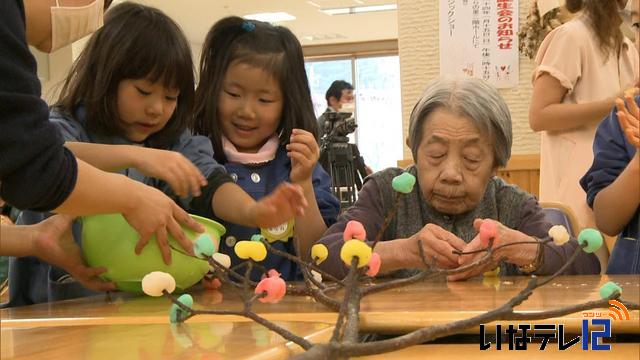 園児とお年寄りがまゆ玉作り