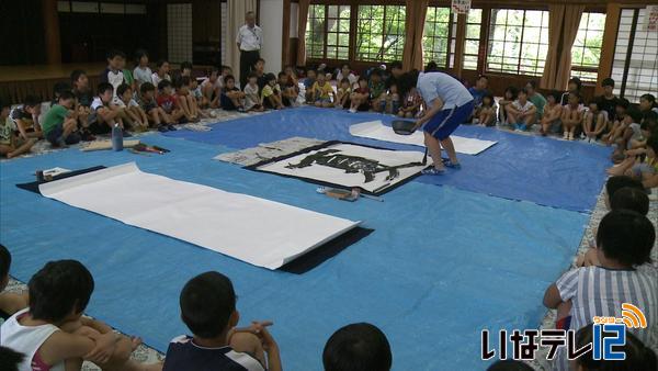 夏休み中の小学生に高校生が書道披露